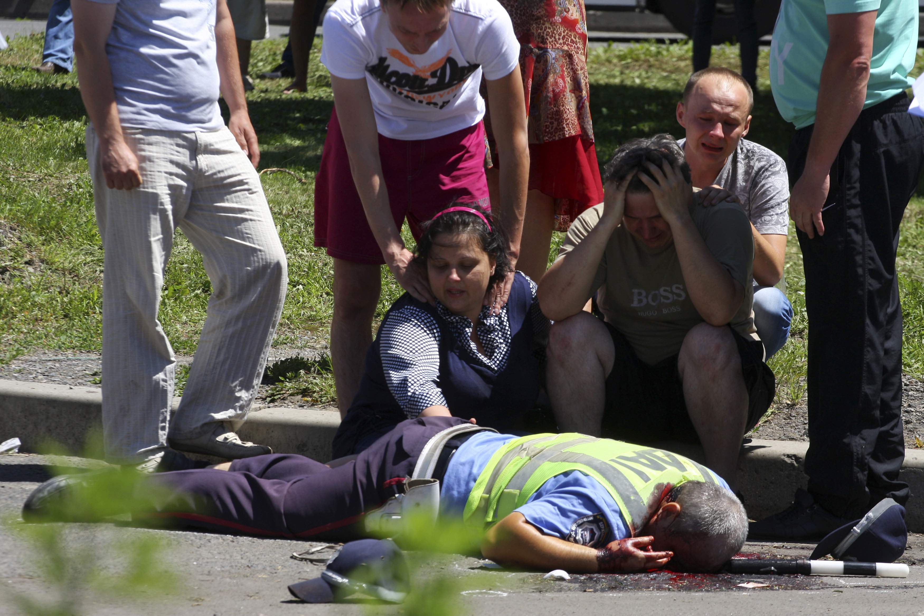 Relatives grieve at the scene where a patrol of traffic police officers was attacked by unknown assailants in Donetsk