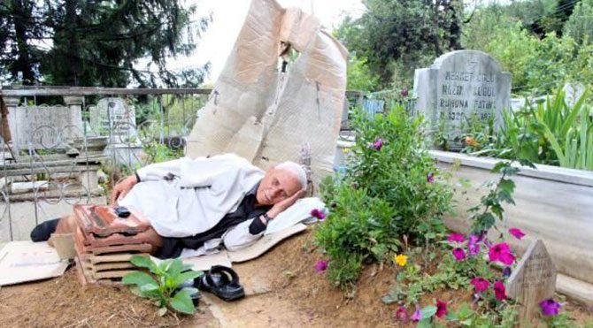 Karısının mezarında uyuyor