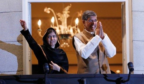 Nobel Peace Prize laureates Malala Yousafzai and Kailash Satyarthi wave and gesture from the balcony of the Grand Hotel in Oslo