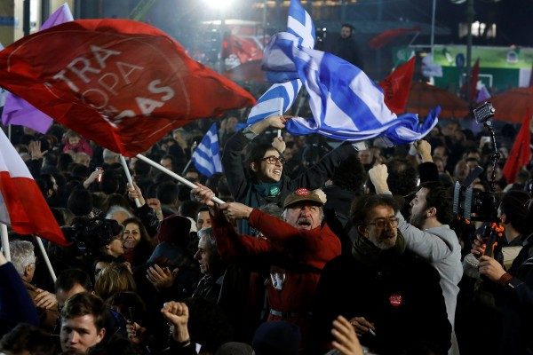 Supporters of radical leftist Syriza party chant slogans and wave Greek national and other flags after winning elections in Athens
