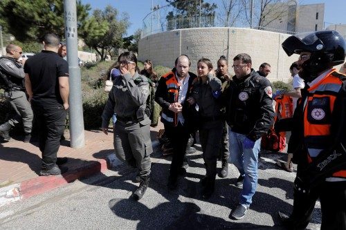 An Israeli border police woman speaks to a medic at the scene of an attack Jerusalem