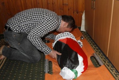 A relative of 18-month-old Palestinian baby Ali Dawabsheh, who was killed after his family's house was set on fire in a suspected attack by Jewish extremists, mourns over his body during his funeral in Duma village near Nablus
