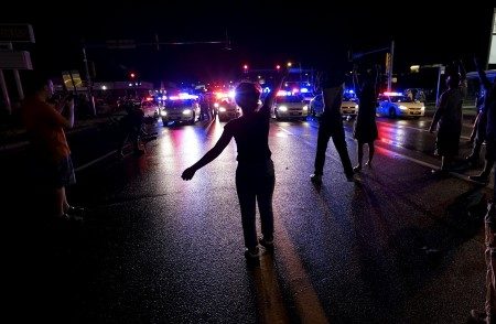 A protester yells at a police line shortly before shots were fired in a police-officer involved shooting in Ferguson