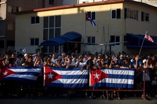 People gather behind Cuban flags near the U.S. embassy in Havana