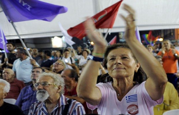 Supporters of leftist Syriza party react at the party's main election kiosk after seeing early results following a general election in Athens