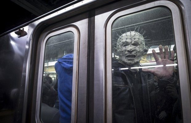 A man dressed up as Pinhead from the Hellraiser series poses for a photo as his subway train pulls away at Times Square station in Manhattan