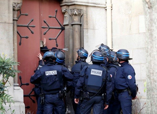 French police force to open the door of the Eglise Neuve church as they secure the area during an operation in Saint-Denis