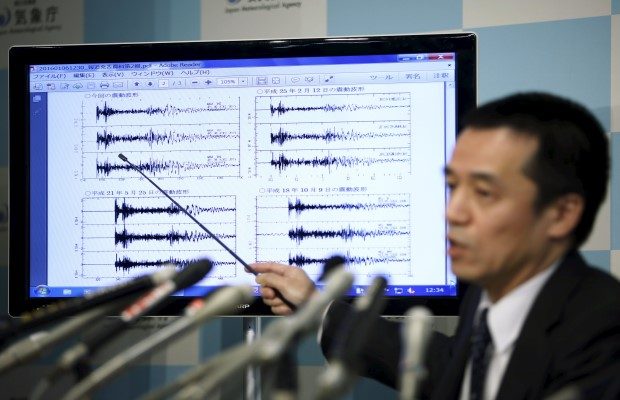 Hasegawa points at a graph of ground motion waveform data observed in Japan during a news conference at the Japan Meteorological Agency in Tokyo