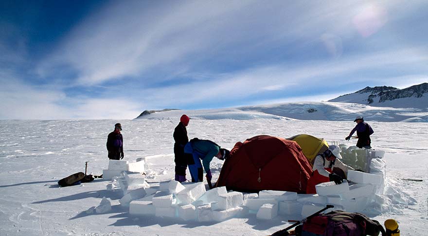 Antarktika’da çadırları rüzgara karşı korumak için buzdan duvar ören ekip.