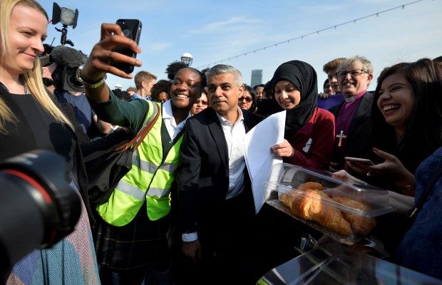 Britain's newly elected mayor Sadiq Khan poses for a selfie photograph with a supporter as he arrives for his first day at work at City Hall in London, Britain May 9, 2016. REUTERS/Hannah McKay