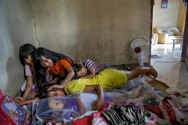 Fotoğraf: National Geographic Kuzenleri ve kardeşleri bir gün önce ölen üç yaşındaki Syahrini Tania Tiranda'ya sarılıp, onunla konuşuyorlar. Onlara göre Syahrini ölmedi, sadece hasta.