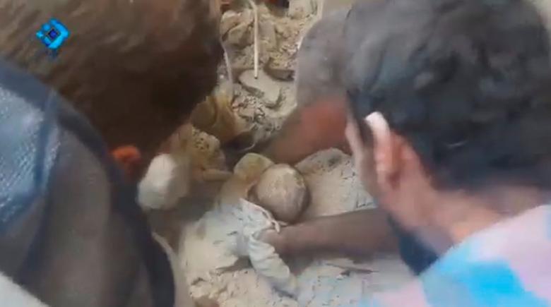 A still image from video posted on social media web sites shows a baby being rescued from rubble of a collapsed building in Aleppo, Syria. Social Media via Reuters TV