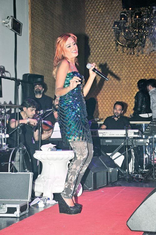 Dolgu topuk ayakkabıları, payetli dantel motifli taytı ve pullu elbisesiyle Tilbe'nin stili biraz göz yordu.