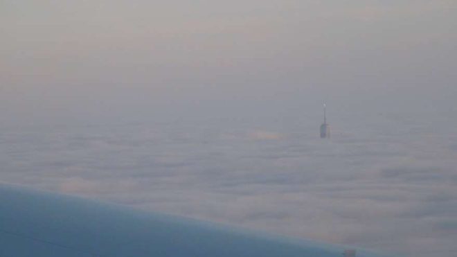 Saat 16:00 - New York gözüktü. Bulutlar üzerinde One World Trade Center 