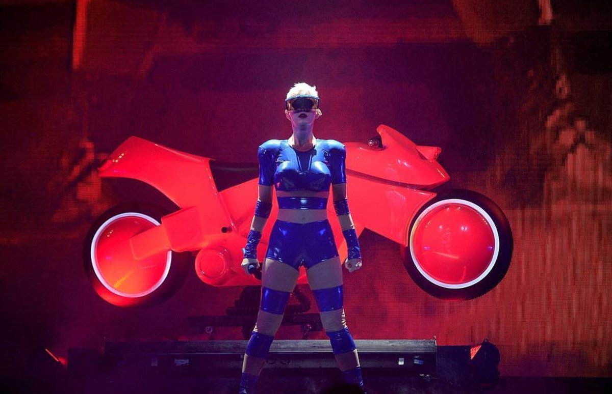 Bir süper kahraman gibi görünen Katy Perry Adam Selman'a ait çizgili mavi bir spor kıyafet giydi. Geleceğe Yolculuk filminden fırlamış gibi görünen Perry aksesuar olarak da ilginç bir gözlük tercih etmiş.