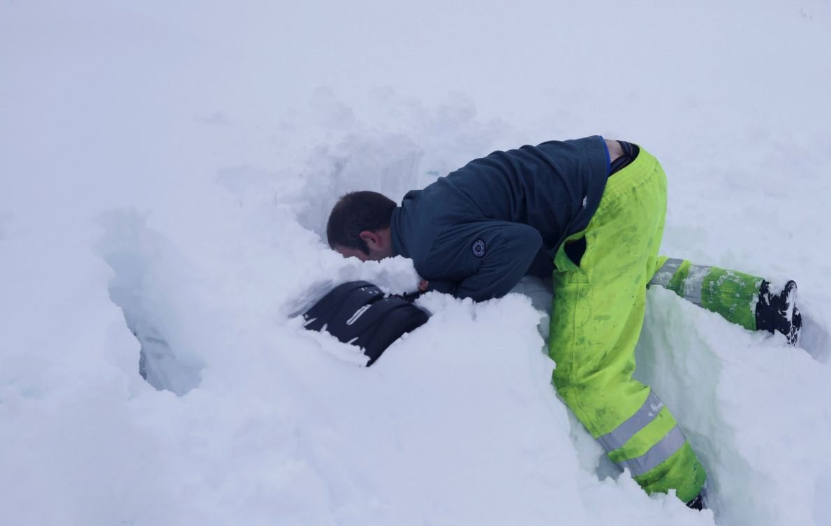 Yoğun kar yağışı İngiltere ve İskoçya'da yaşamı durma noktasına getirdi. Reuters'ın fotoğrafında görüntülenen bir adam aracını kürekle aradı.