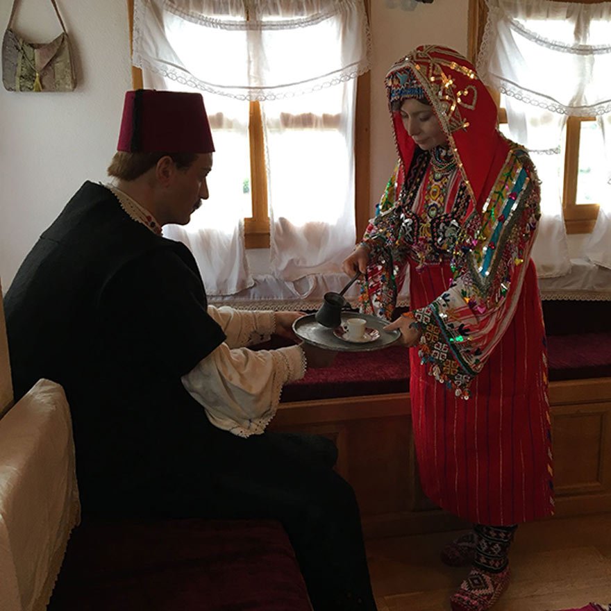 Sedire oturmuş olan Ali Rıza Bey ile ona kahve ikram eden karısı Zübeyde Hanım.