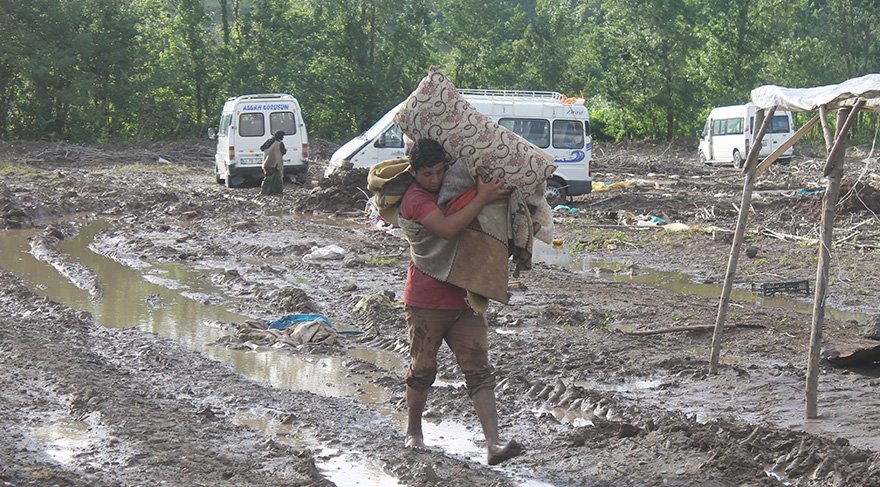 Mevsimlik işçiler selden zarar gören eşyalarını kurtarmaya çalıştı. Foto: AA