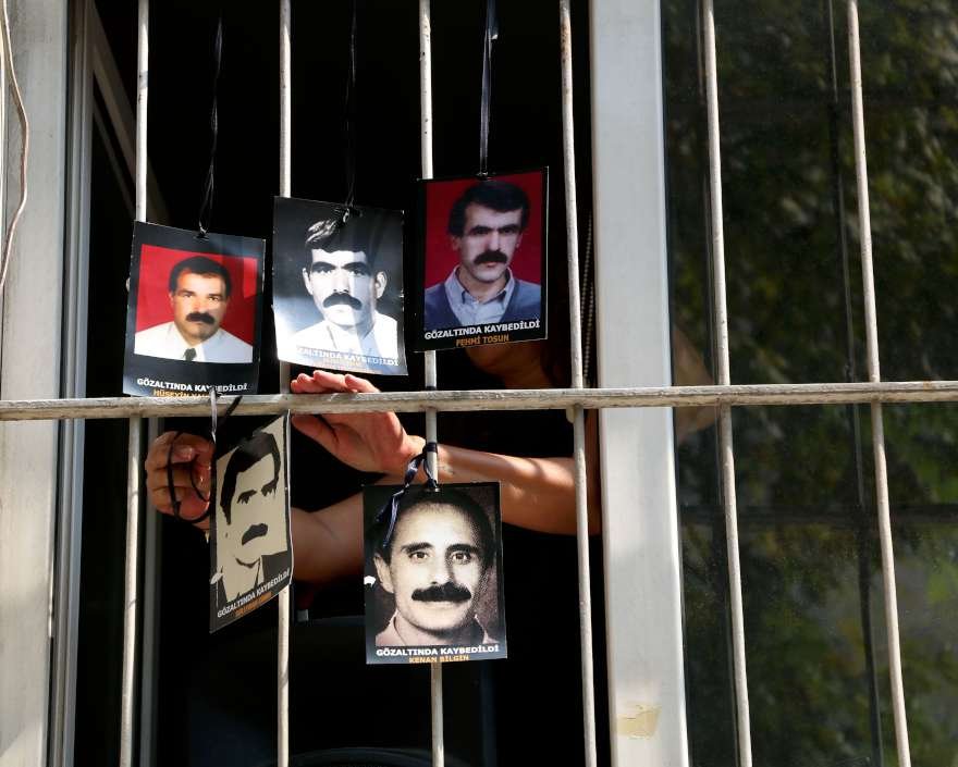 Gözaltında kaybedilenlerin fotoğrafları yakınları tarafından İHD'nin penceresine asıldı. Foto DHA
