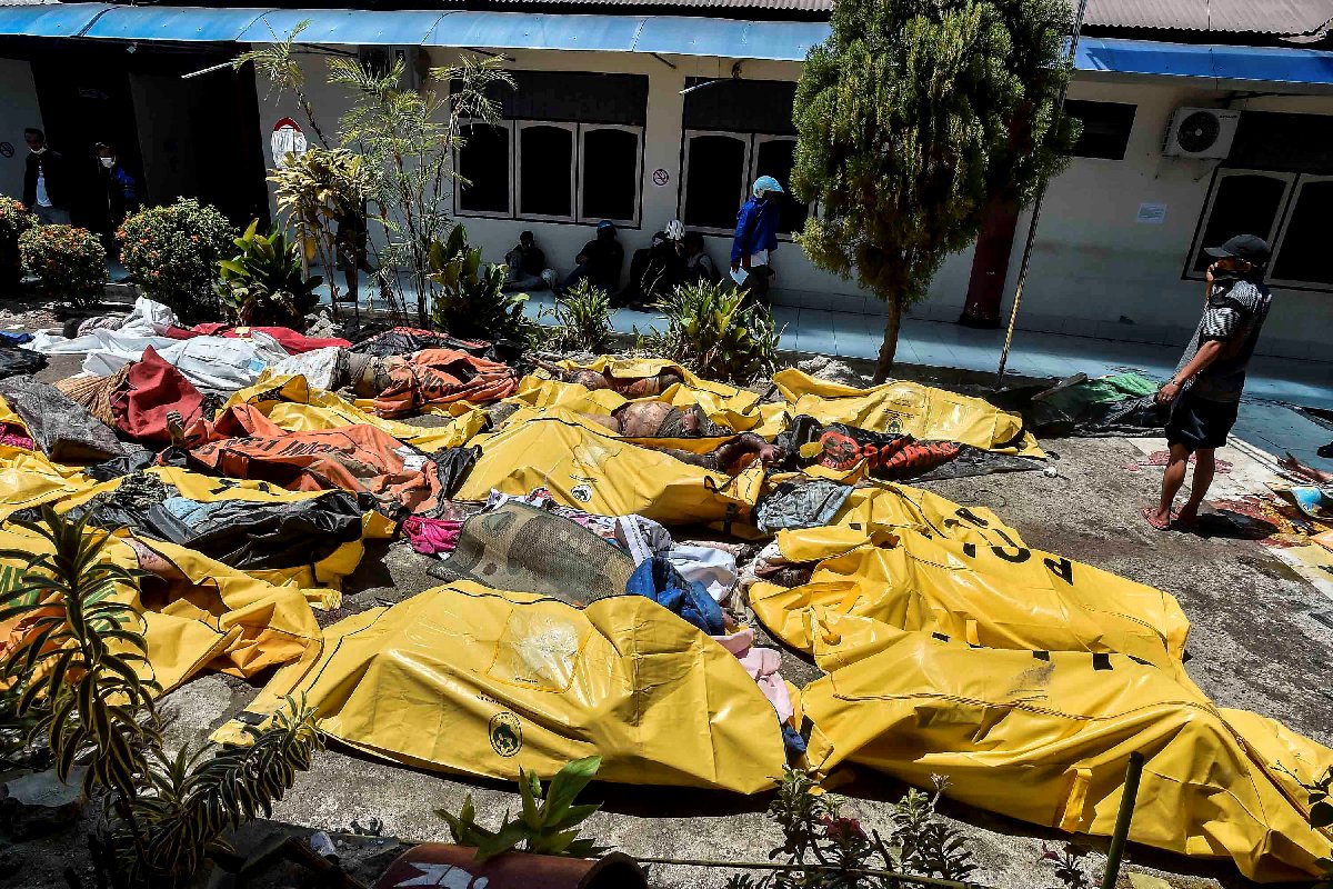 Peş peşe felaket yaşayan Endonezya'daki hastanelerde ve morglarda yer kalmadığı için cansız bedenler bahçeye çıkarıldı.