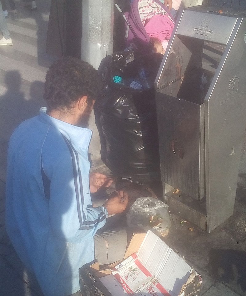 Çöpten bulduğu bir kaç parça yiyecek için el açıp şükretti. Foto: Sözcü