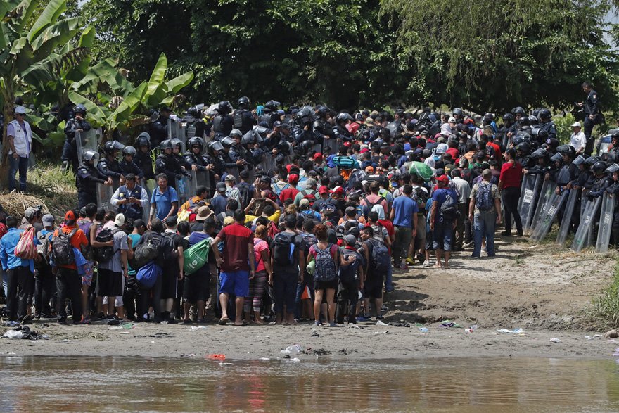 Meksika sınırına nehir üzerinden geçen Honduraslı göçmenleri Meksikalı polisler karşıladı.