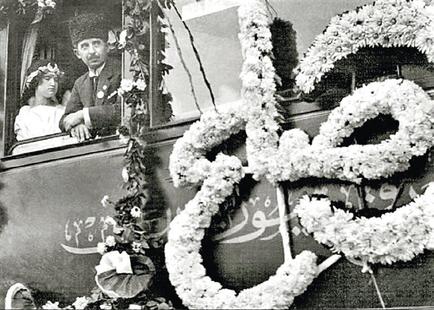 Lozan dönüşü çiçeklerle karşılanan İsmet İnönü, ‘sulh’ yazılı vagonda ‘barış perisi’ kılığında Uzma adlı kız çocuğuyla (1923). 