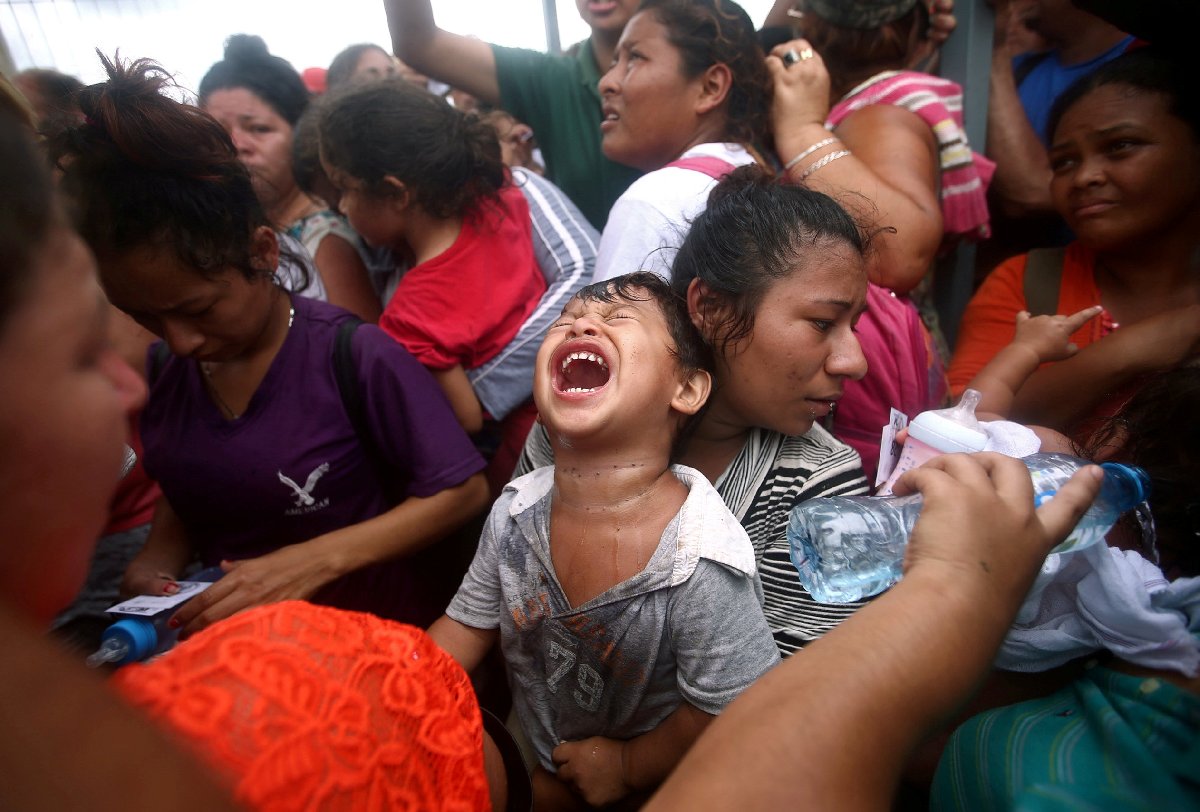 Ülkelerinden kaçan Guatemalalılardan bazıları, biber gazı sıkan Meksika polisinin ardından bayıldı.