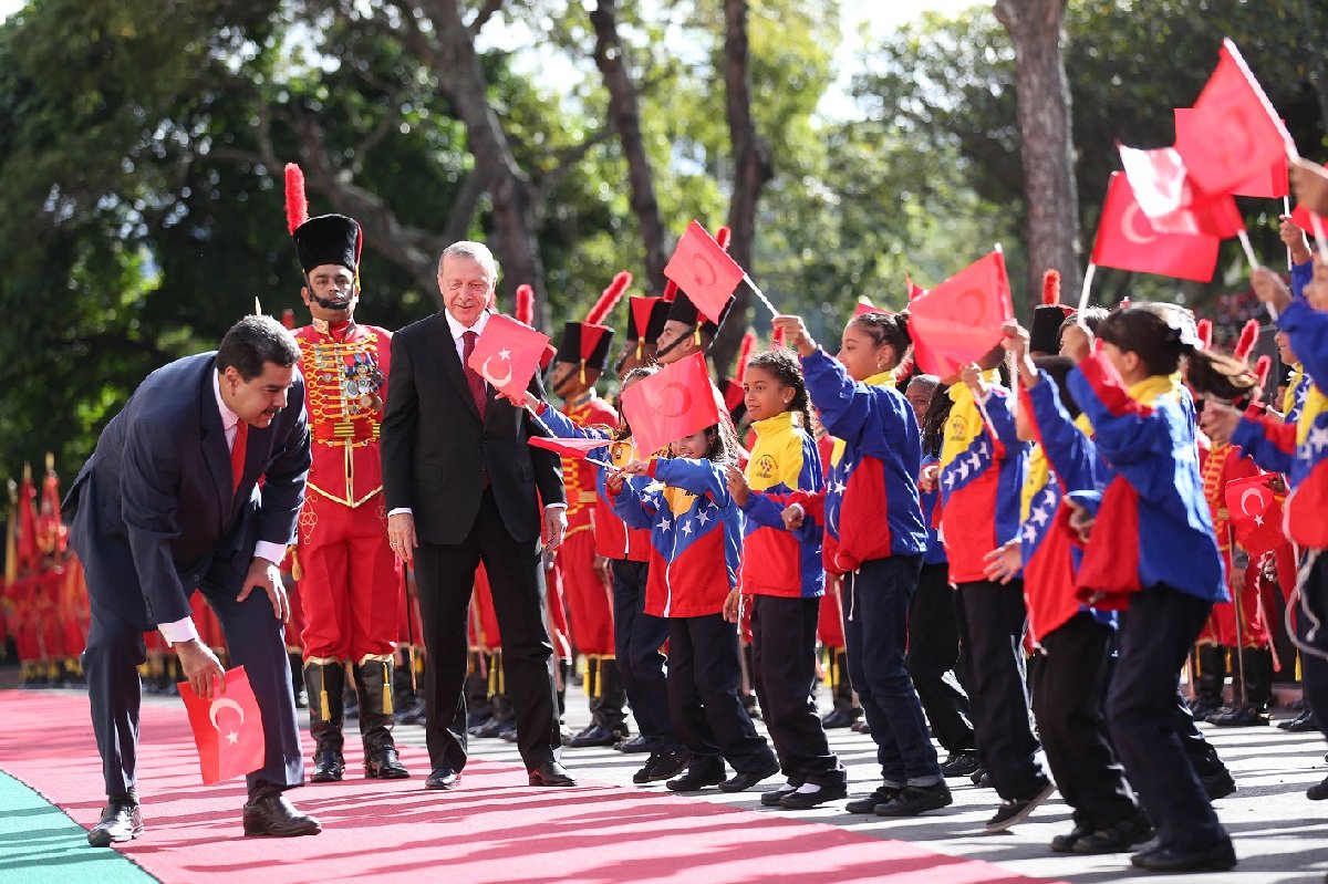 Bayrağı fark eden Maduro, bu konuda hassasiyeti bilinen Erdoğan'dan önce eğilerek bayrağı aldı.