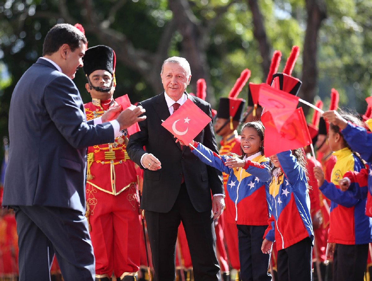 Maduro, daha sonra bayrağı çocuklara gösteriyor.