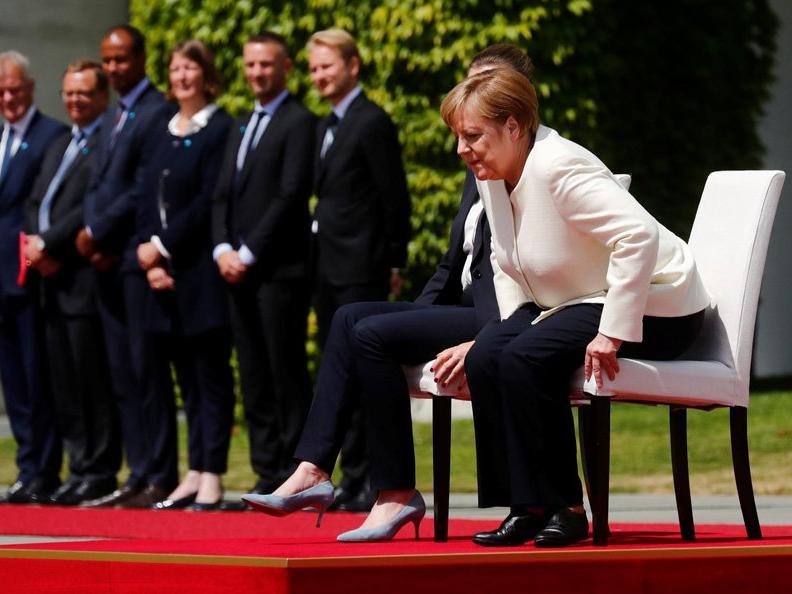 Titreyen Merkel'e çözüm: Sandalyeye oturttular